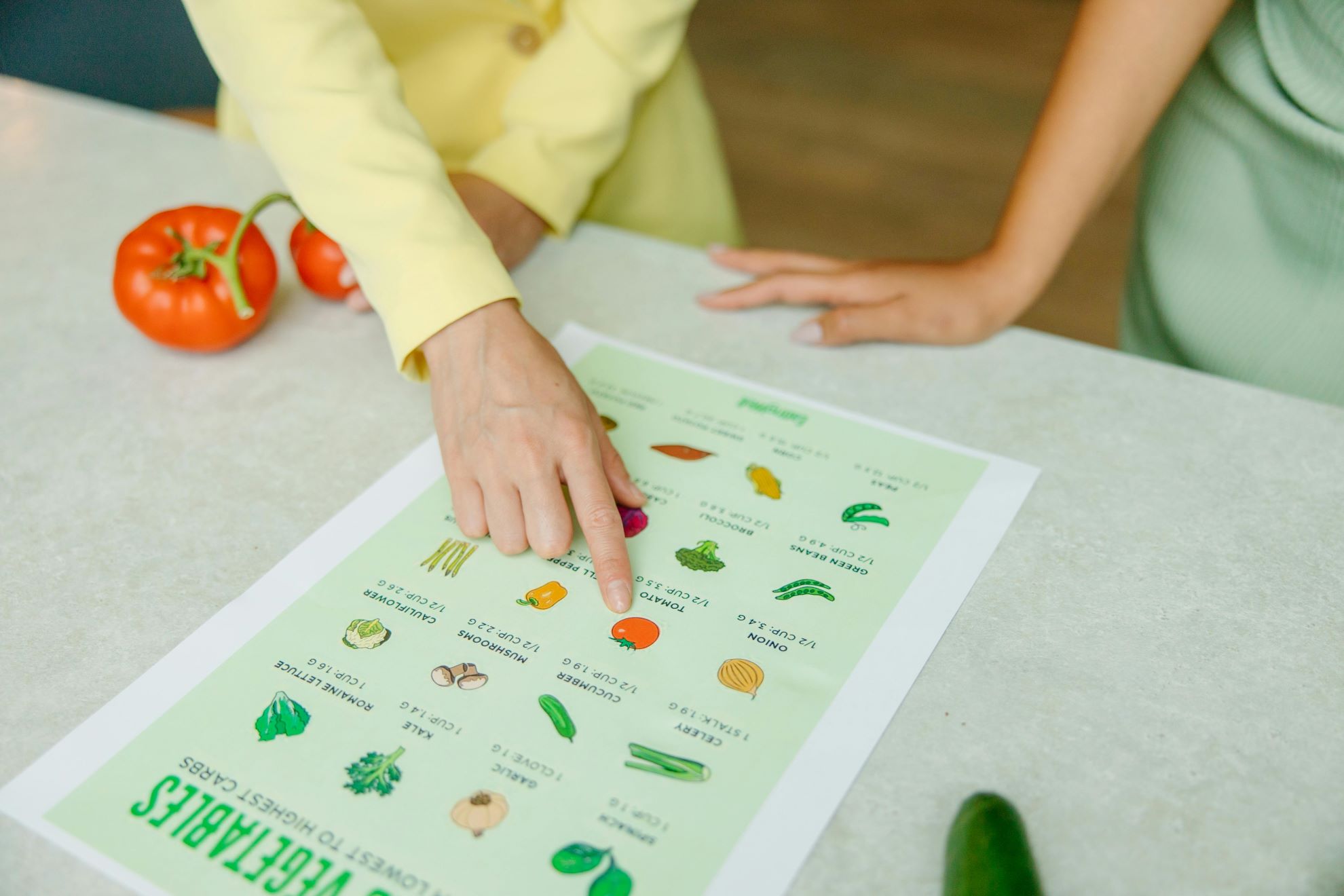 La dietista illustra ad una paziente le proprietà di alcuni alimenti su una tabella